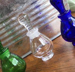 Glass Perfume Bottle with the Clear as the prefominant fragrancia perfume bottle in the middle.