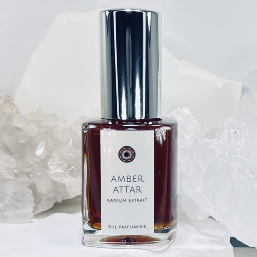 Amber Attar Parfum Extrait in a luxury perfume bottle with shiny silver sprayer.