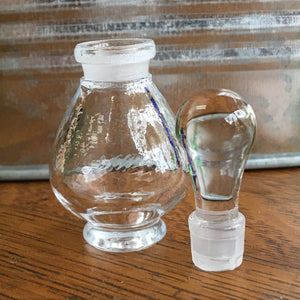 Clear glass Potion Genie Bottle with Top off so you can see the ground glass stopper with plastic ring. 