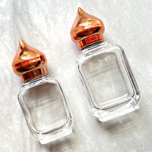 Clear Glass 10 ml and 15 ml Gift Bottles that are unisex and have Copper Pointed Caps.