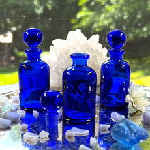 Load image into Gallery viewer, COBALT BLUE Glass Apothecary Bottles in half ounce size on a silver tray sparkling in the sunshine.