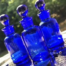 Load image into Gallery viewer, COBALT BLUE Glass Apothecary Bottles in one ounce size on a silver tray sparkling in the sunshine.