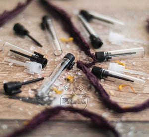 A scattered array of glass vials with natural/opaque plugs or black plugs. 