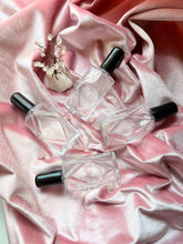 Load image into Gallery viewer, Scattered Diamond Perfume Bottles lying down on ther sides showcasing masculinity and femininity.