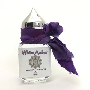 10ml Gift Perfume Bottle of White Amber Perfume Oil. Clear Glass Perfume Bottle with a silver pointed cap. Embellished with Sari Ribbon to make the perfect present.