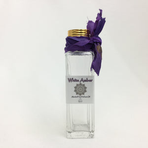 30ml Gift Bottle of White Amber Perfume Oil. Clear glass perfume bottle with a gold ribbed cap and Sari Ribbon accent.