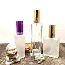 Load image into Gallery viewer, Assorted Perfume Bottles. Our focus is the 2 oz. Perfume Spray bottle. Frosted Glass with Purple Atomizer Sprayer Top and Over Cap for Perfume Oils, Essential Oils or Fragrance Oils.